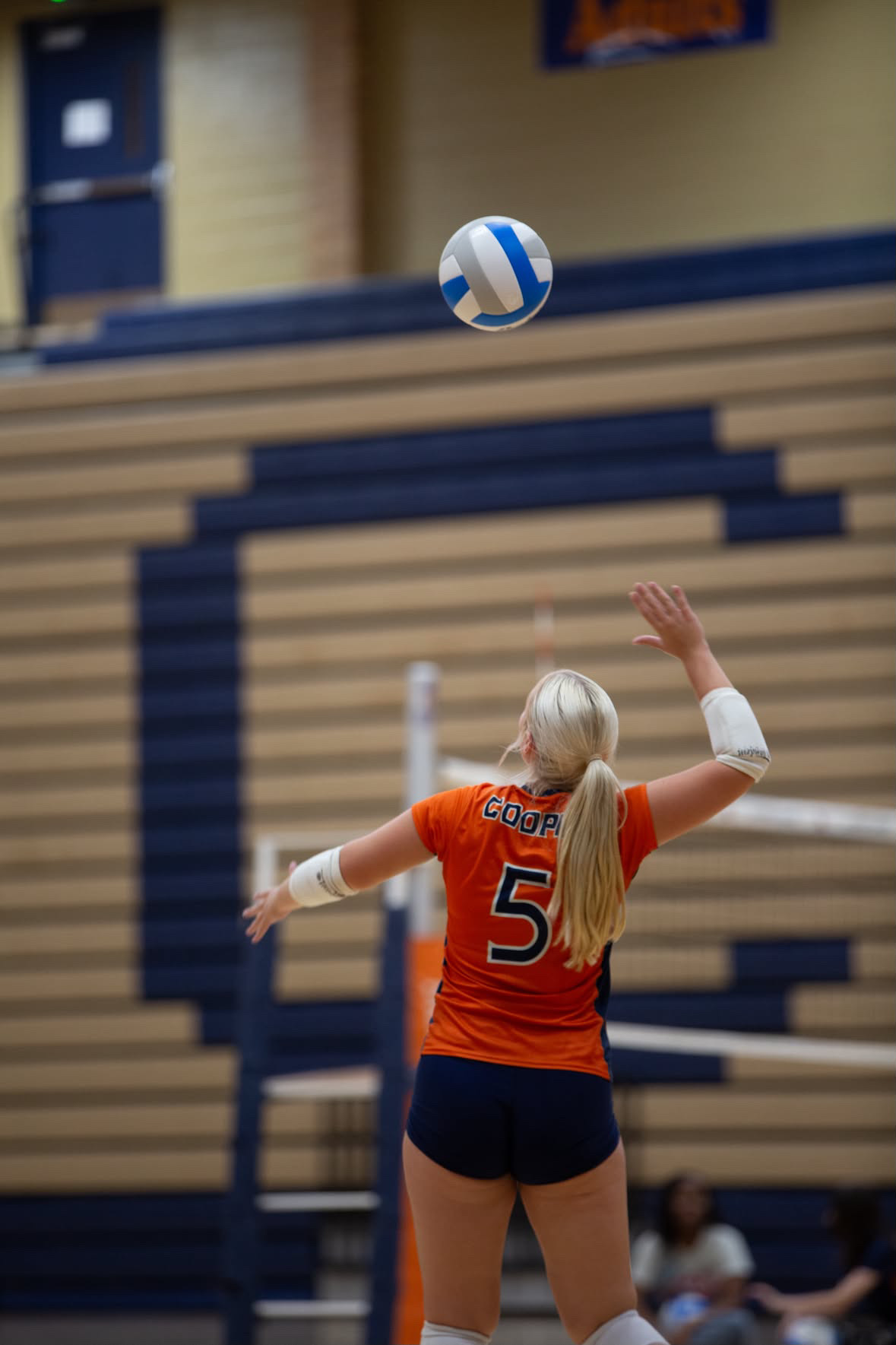 Volleyball player tossing the ball up to serve